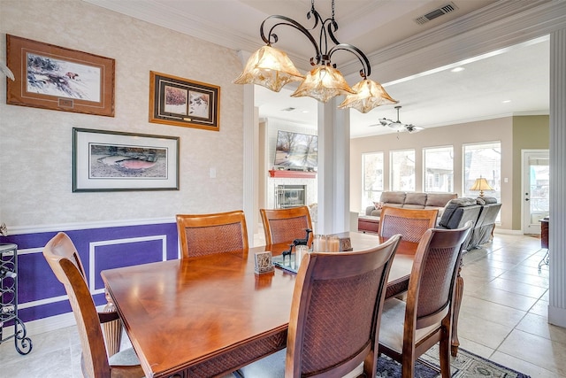 dining area featuring light tile patterned flooring, ceiling fan with notable chandelier, and ornamental molding