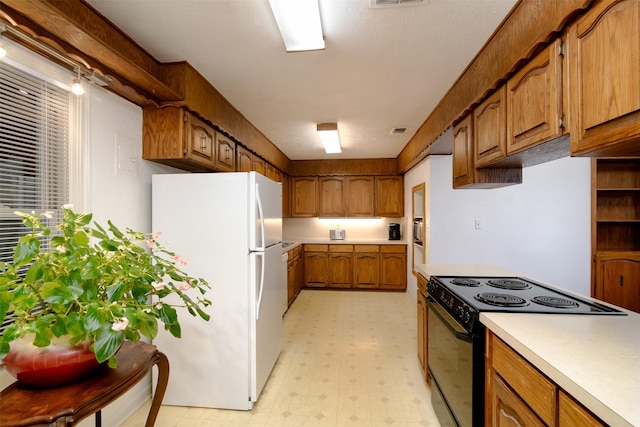 kitchen with white refrigerator and black electric range