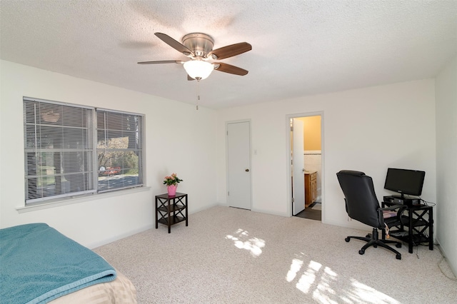 bedroom with a textured ceiling, ceiling fan, ensuite bathroom, and light colored carpet