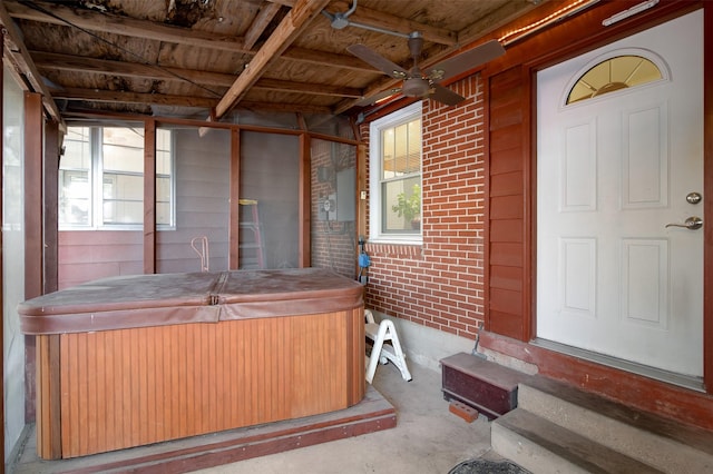 misc room featuring ceiling fan, brick wall, and a hot tub