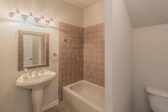 bathroom with toilet, tiled shower / bath, and tile patterned flooring