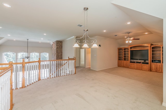 unfurnished living room featuring ceiling fan, lofted ceiling, and light colored carpet