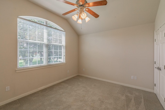 carpeted spare room featuring ceiling fan and lofted ceiling