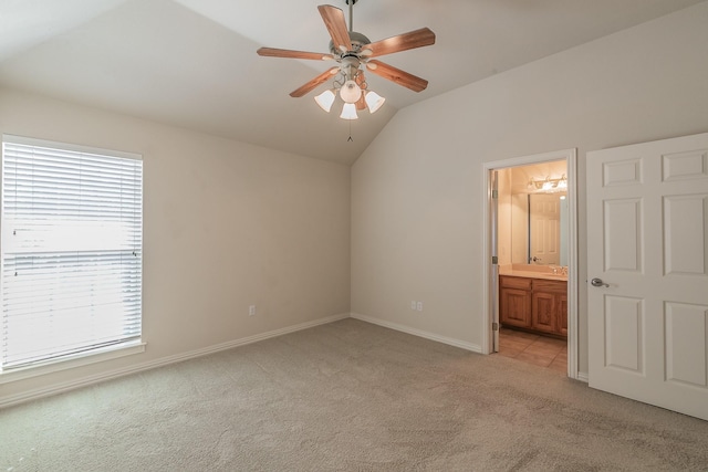 unfurnished bedroom with light carpet, ceiling fan, lofted ceiling, and connected bathroom