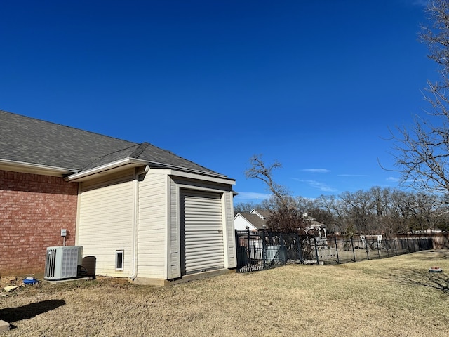 exterior space featuring central AC unit and a yard