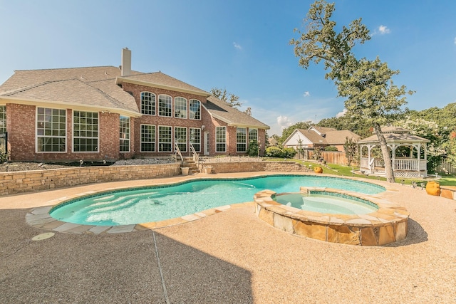 view of swimming pool featuring a patio area, a gazebo, and an in ground hot tub