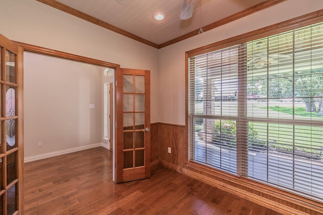 spare room with wooden walls, ceiling fan, dark hardwood / wood-style floors, french doors, and ornamental molding