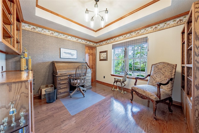 office area with hardwood / wood-style floors, a tray ceiling, ornamental molding, and a chandelier