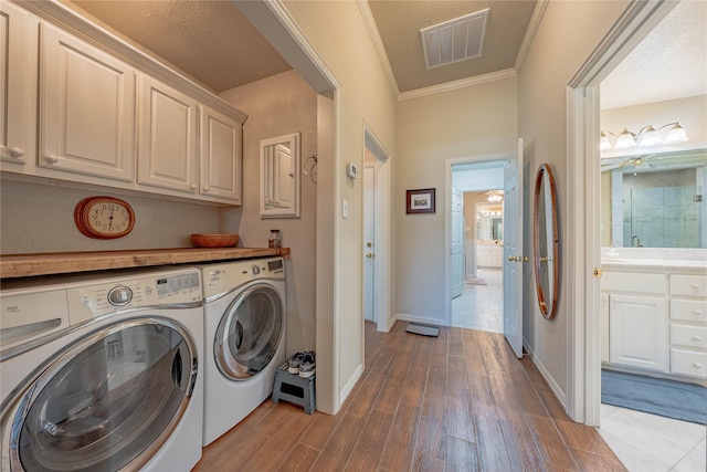 laundry room with washer and clothes dryer, ceiling fan, dark hardwood / wood-style floors, cabinets, and crown molding