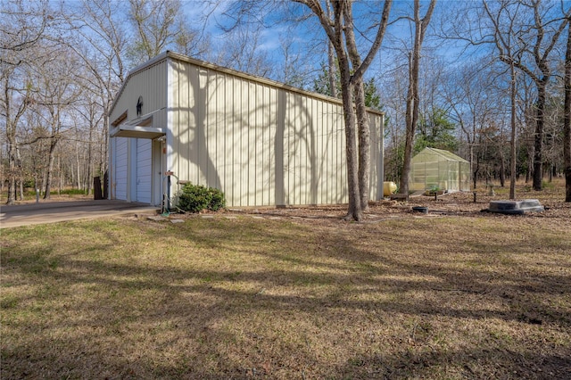 view of side of home featuring a lawn and an outdoor structure