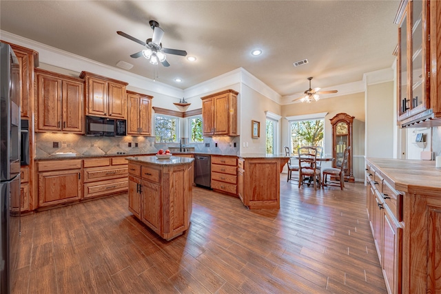 kitchen featuring tasteful backsplash, dishwasher, a wealth of natural light, and a center island