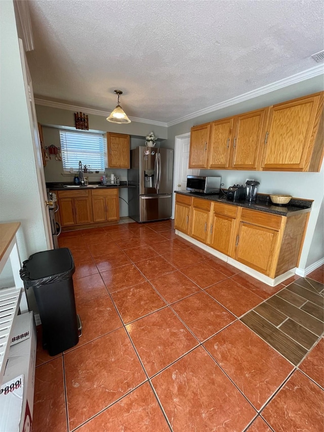 kitchen with stainless steel appliances, sink, a textured ceiling, crown molding, and dark tile patterned floors