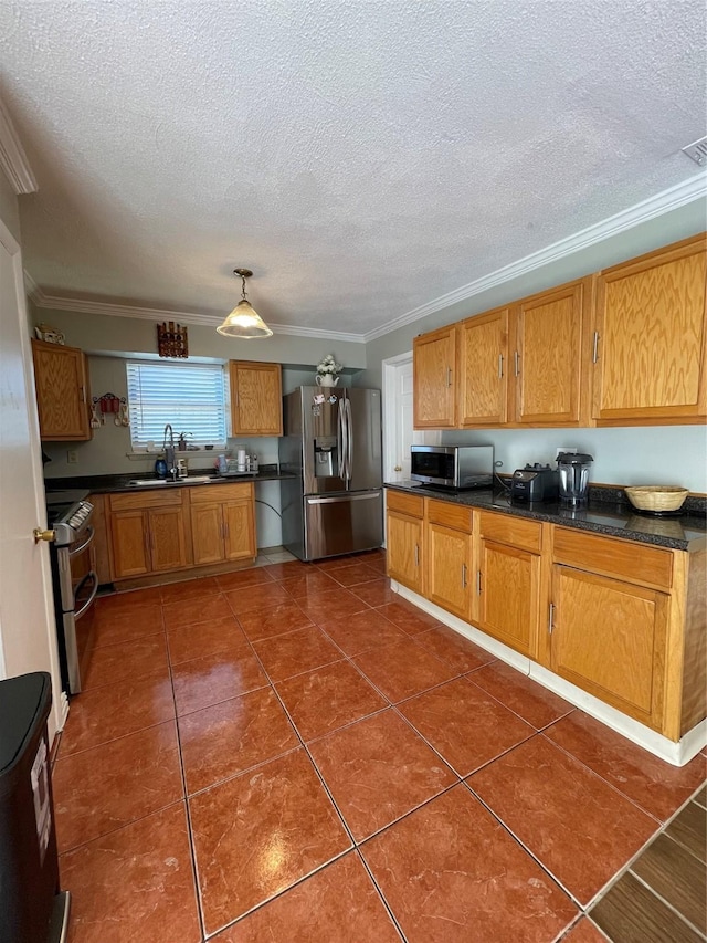 kitchen with sink, crown molding, dark tile patterned floors, appliances with stainless steel finishes, and a textured ceiling