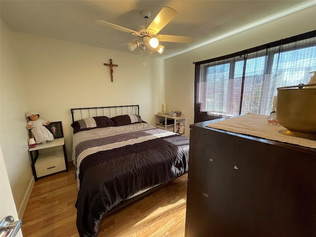 bedroom with ceiling fan and light hardwood / wood-style flooring