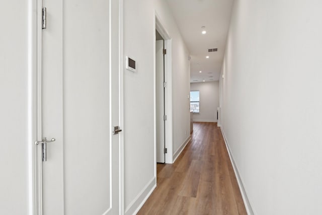 corridor featuring visible vents, recessed lighting, baseboards, and light wood-style floors