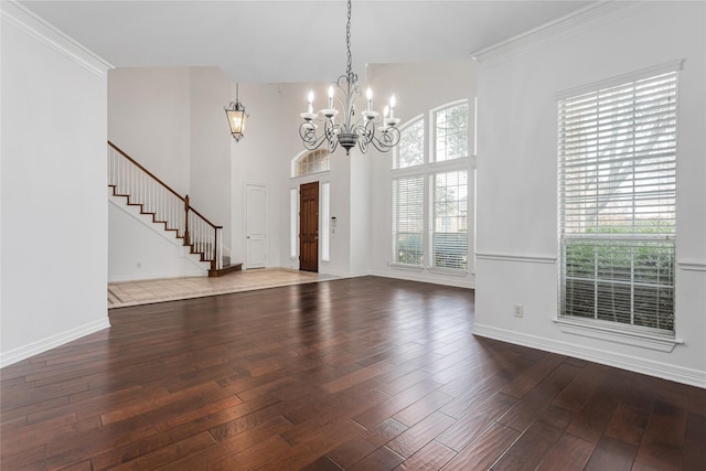 interior space featuring ornamental molding, a healthy amount of sunlight, hardwood / wood-style flooring, and a notable chandelier