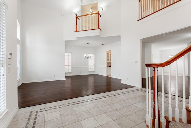 tiled entrance foyer with a towering ceiling and a chandelier