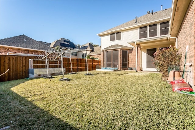 back of house featuring a sunroom and a yard