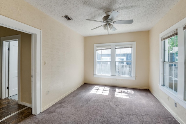 carpeted empty room with ceiling fan and a textured ceiling