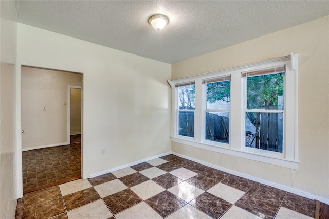 unfurnished room featuring a textured ceiling