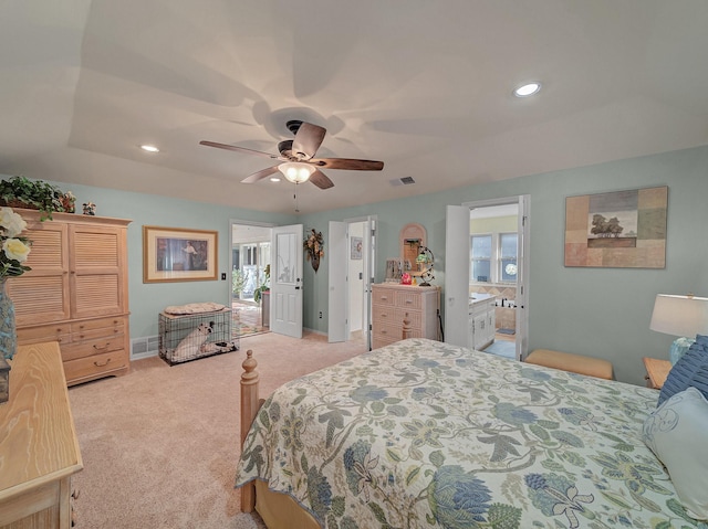 carpeted bedroom with ensuite bathroom, ceiling fan, and a raised ceiling