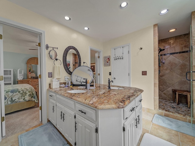 bathroom with tiled shower and vanity