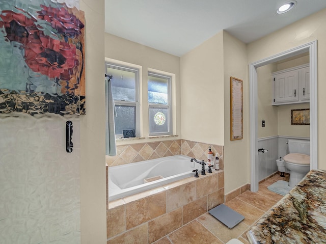 bathroom featuring toilet and tiled bath