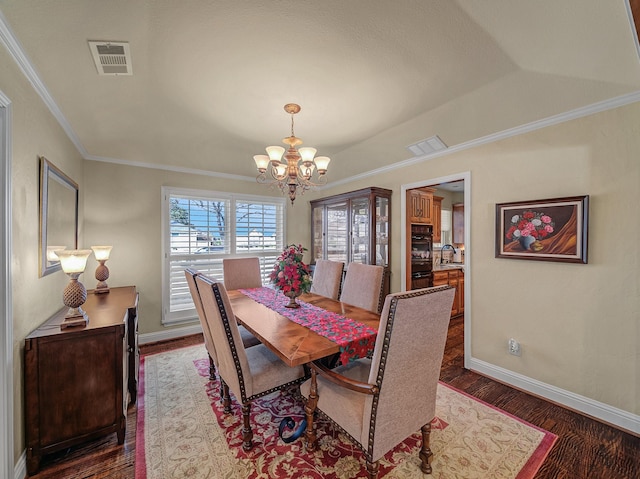 dining area featuring sink, dark hardwood / wood-style floors, crown molding, and a notable chandelier