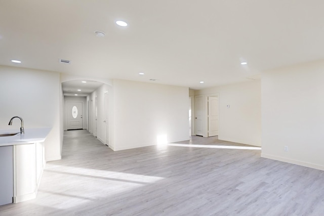 empty room with light hardwood / wood-style floors and sink