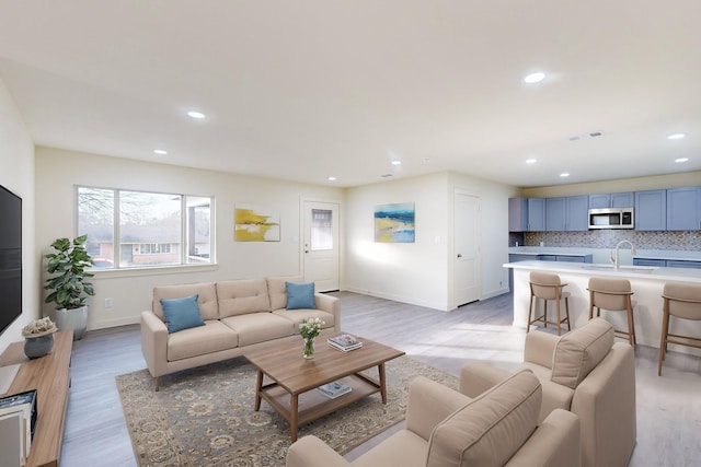 living room featuring sink and light hardwood / wood-style flooring