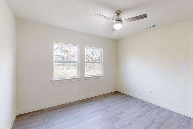 empty room with ceiling fan and light hardwood / wood-style flooring