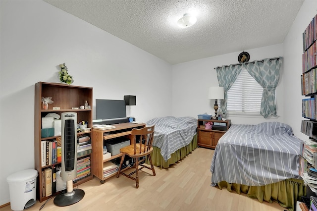 bedroom featuring light wood-type flooring and a textured ceiling