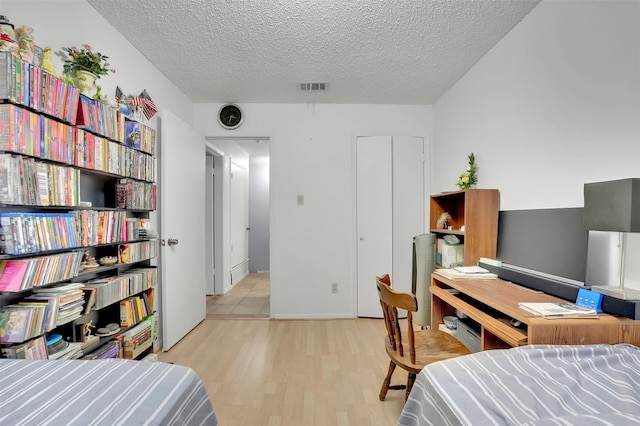 bedroom featuring a textured ceiling and light wood-type flooring