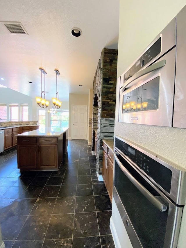 kitchen with stainless steel appliances, pendant lighting, a chandelier, and a center island