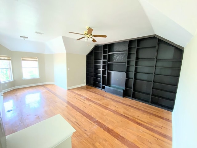 additional living space with ceiling fan, lofted ceiling, hardwood / wood-style floors, and built in shelves