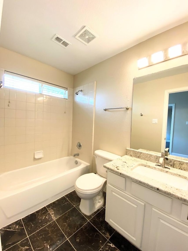 full bathroom with toilet, vanity, and tiled shower / bath