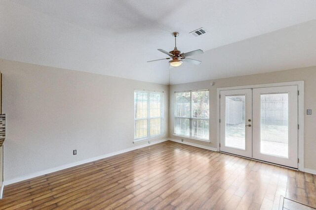 living room featuring french doors, lofted ceiling, ceiling fan, a fireplace, and light hardwood / wood-style floors