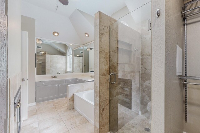 bathroom featuring tile patterned floors, vaulted ceiling, vanity, a relaxing tiled tub, and ceiling fan