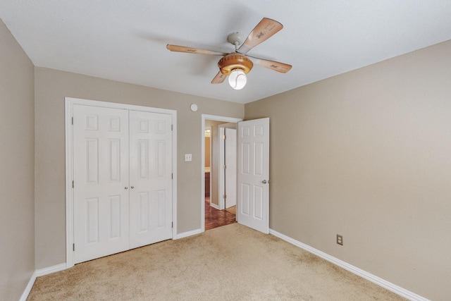 unfurnished bedroom featuring ceiling fan, light carpet, and a closet