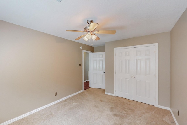 unfurnished bedroom with light colored carpet, a closet, and ceiling fan