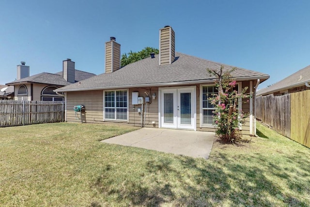 rear view of property with a patio, a lawn, and french doors