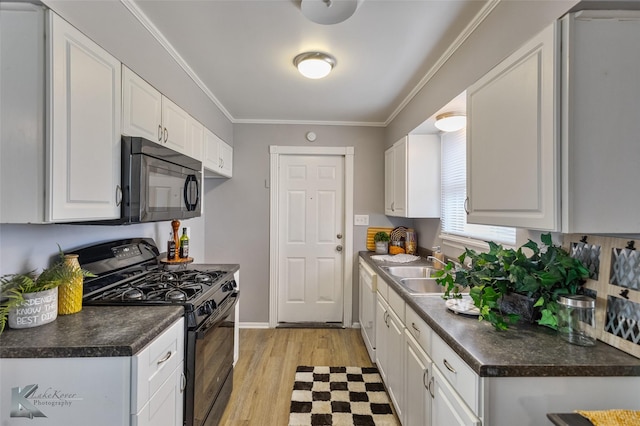 kitchen featuring white cabinetry, ornamental molding, black appliances, light hardwood / wood-style flooring, and sink