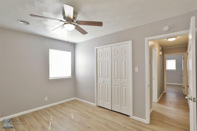 unfurnished bedroom featuring ceiling fan, a closet, and light hardwood / wood-style flooring