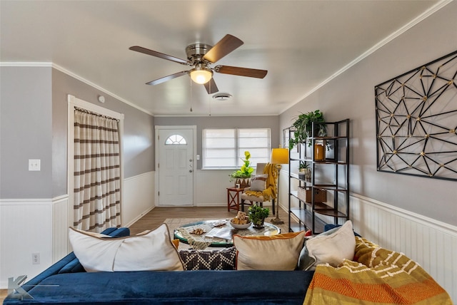 living room with ceiling fan, wood-type flooring, and ornamental molding