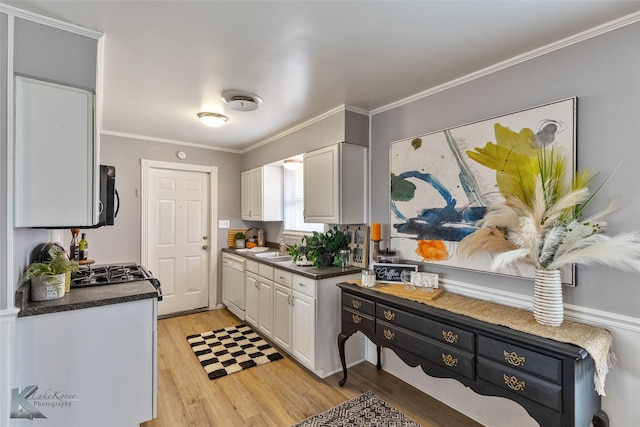 kitchen featuring white cabinets, sink, white dishwasher, light hardwood / wood-style flooring, and crown molding