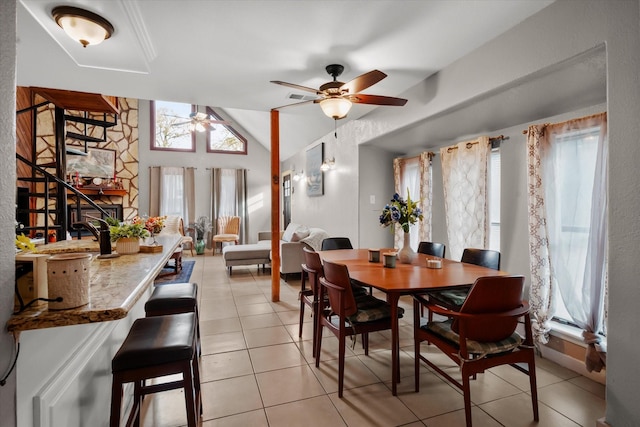 dining area featuring ceiling fan, vaulted ceiling, and light tile patterned flooring