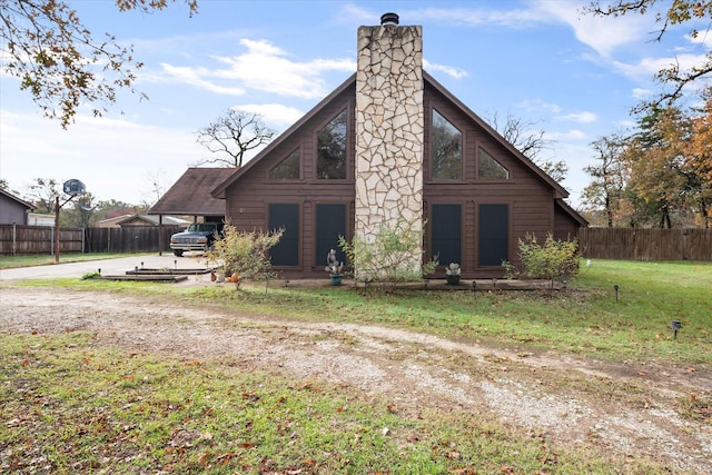 rear view of property featuring a lawn