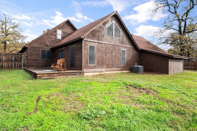 rear view of house featuring central air condition unit and a yard