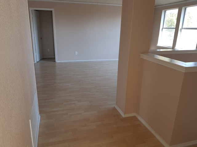 hall with crown molding and light wood-type flooring