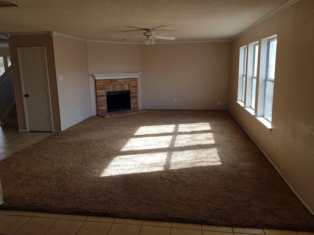 unfurnished living room with a textured ceiling, ceiling fan, light tile patterned floors, and a fireplace